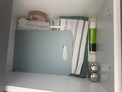 a white drawer with some towels and a clock at Mountain view Lux Apartment in Bansko
