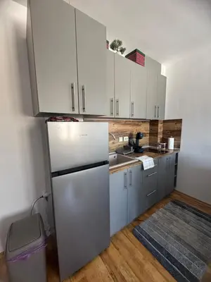 a kitchen with white cabinets and a refrigerator at Mountain view Lux Apartment in Bansko