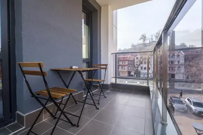 a balcony with chairs and a table and a window at Heart of Plovdiv Studio Apartment Free Parking in Plovdiv