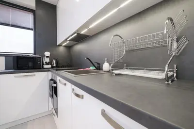 a kitchen with white cabinets and a sink at Heart of Plovdiv Studio Apartment Free Parking in Plovdiv