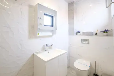 a white bathroom with a sink and a toilet at Heart of Plovdiv Studio Apartment Free Parking in Plovdiv