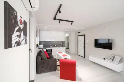 a living room with a couch and a red chair at Heart of Plovdiv Studio Apartment Free Parking in Plovdiv