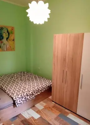 a bedroom with a bed next to a wooden cabinet at Apartment Sofia top center in Sofia