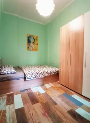 a green room with a bed and a wooden cabinet at Apartment Sofia top center in Sofia