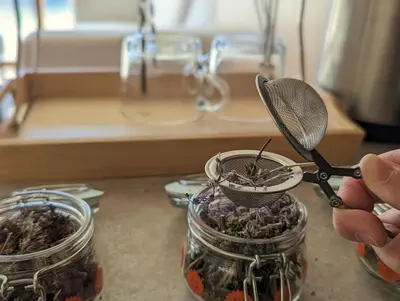 a person holding a pair of scissors in a jar at Woodsy views 1 bedroom apartment in Bansko