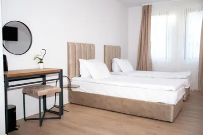 a bedroom with a bed and a table and a mirror at Орбелус in Bansko