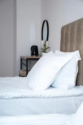 a bed with white pillows on top of it at Орбелус in Bansko