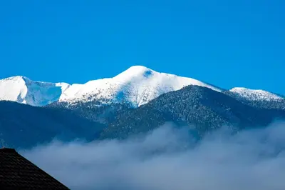 a mountain covered in snow with clouds in front of it at Орбелус in Bansko