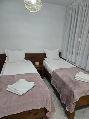 two beds in a room with white towels on them at Gondola Peak Apartment in Bansko