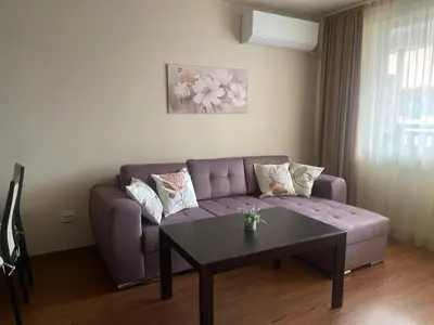 a living room with a purple couch and a table at Royal Towers Bansko Apartment - Gondola in Bansko
