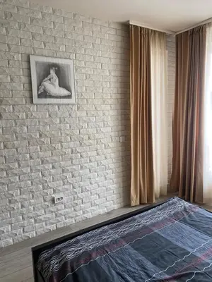 a bedroom with a brick wall and a bed at Royal Towers Bansko Apartment - Gondola in Bansko