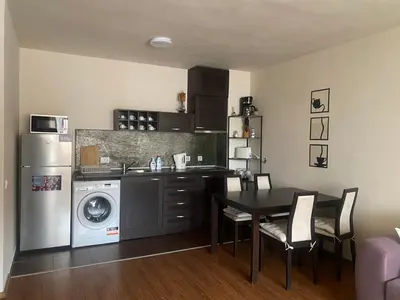a kitchen with a table and a kitchen with a washing machine at Royal Towers Bansko Apartment - Gondola in Bansko