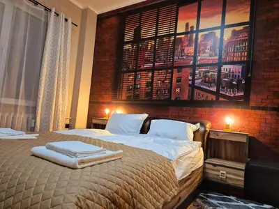 a bedroom with a large bed with a brick wall at Botev's Finest 3BR in Sofia
