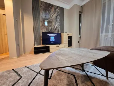 a living room with a tv and a coffee table at Botev's Finest 3BR in Sofia