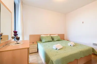 a bedroom with a bed with two towels on it at Niki's cosy place in Bansko