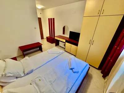 a bedroom with a large bed and a television at Basment Rooms - Todorini Kuli in Bansko