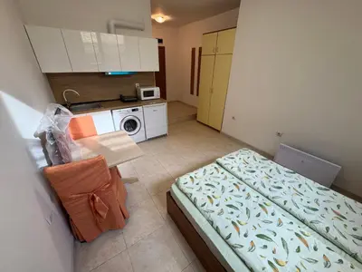 a small room with a bed and a kitchen at Basment Rooms - Todorini Kuli in Bansko