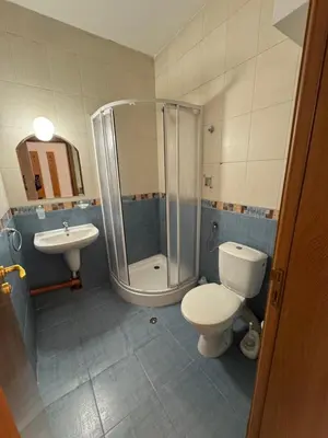 a bathroom with a shower and a toilet and a sink at Basment Rooms - Todorini Kuli in Bansko