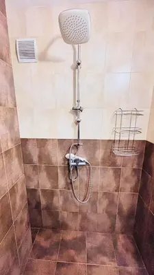 a shower with a shower head in a bathroom at Cozy Suite Vitosha street Center in Sofia