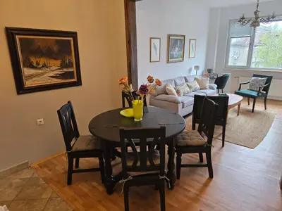 a living room with a table and chairs and a couch at Cozy Suite Vitosha street Center in Sofia