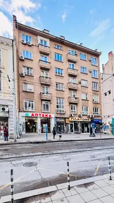 a large brick building on a city street at Cozy Suite Vitosha street Center in Sofia