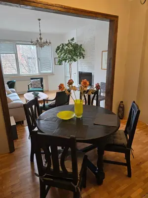 a dining room with a wooden table and chairs at Cozy Suite Vitosha street Center in Sofia