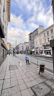 a person with an umbrella standing on a city street at Cozy Suite Vitosha street Center in Sofia