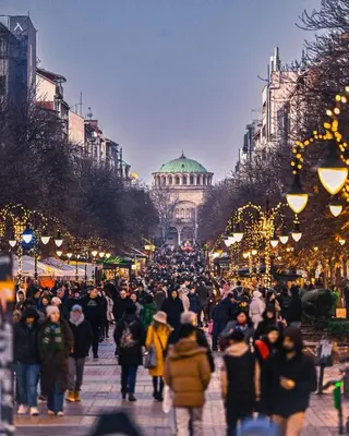 a crowd of people walking down a street at night at Cozy Suite Vitosha street Center in Sofia