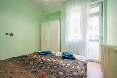 a bedroom with a bed with two blue towels on it at 2 bedroom Urban retreat in Sofia