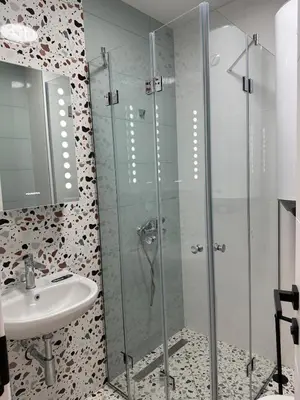 a bathroom with a glass shower and a sink at Lovely Stylish Brand New Flat in Sofia