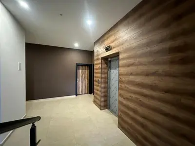 a hallway with a wooden wall and a door at Апартамент Гончеви in Velingrad