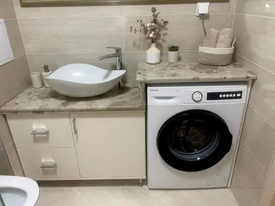 a bathroom with a washing machine and a sink at Апартамент Гончеви in Velingrad