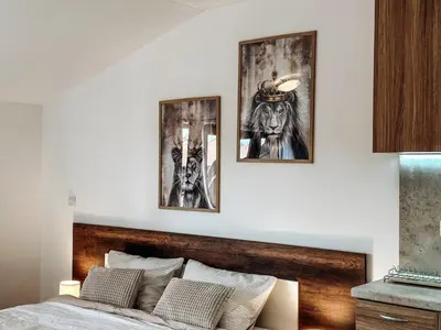 a bedroom with a bed with three pictures on the wall at Pirin Apartament in Bansko
