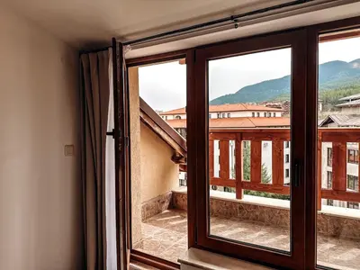 a window with a view of a balcony at Pirin Apartament in Bansko