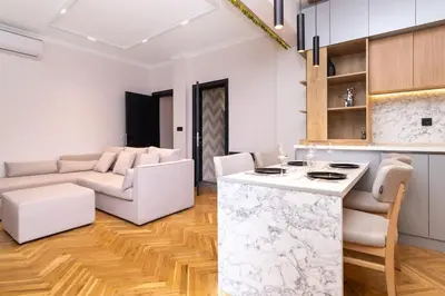 a kitchen and living room with a counter and a table at Brand new Apartments in Sofia Center, Steps to Metro, NDK, Vitosha boulevard in Sofia