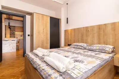 a bedroom with a large bed with a wooden headboard at Brand new Apartments in Sofia Center, Steps to Metro, NDK, Vitosha boulevard in Sofia