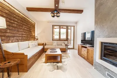 a living room with a couch and a fireplace at Host2U Mountain 2 Bedrooms - Fireplace in Bansko