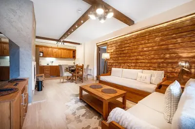 a living room with a couch and a table at Host2U Mountain 2 Bedrooms - Fireplace in Bansko