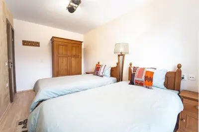 two beds sitting next to each other in a bedroom at Host2U Mountain 2 Bedrooms - Fireplace in Bansko