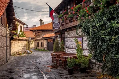 an alley with tables and chairs on a building at Host2U Authentic Bansko Apartment - Free Parking in Bansko