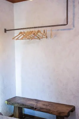 a wooden bench sitting next to a wall at Host2U Authentic Bansko Apartment - Free Parking in Bansko