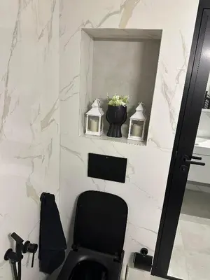 a bathroom with a black chair and a mirror at Cherry in Sofia