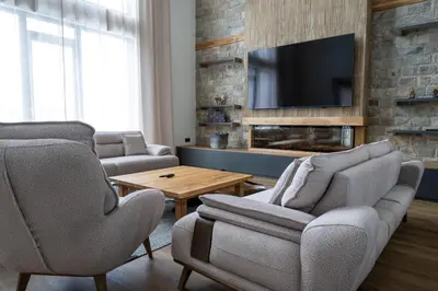 a living room with two chairs and a tv at Chalet Pamporovo in Pamporovo
