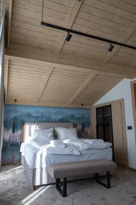 a large bed in a room with a wooden ceiling at Chalet Pamporovo in Pamporovo