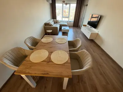 a living room with a wooden table and chairs at PanOrama Luxury Apartments in Panagyurishte