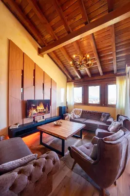 a living room with couches and a table and a fireplace at Host2U Penthouse 2-Bedrooms The Best View - Free Parking in Bansko