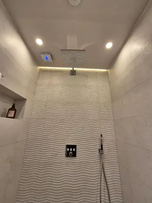 a shower stall in a bathroom with a striped wall at The VERTEX in Sofia