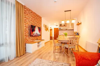 a kitchen and dining room with a brick wall at Golden Lake 526 at Oak Residence in Smolyan