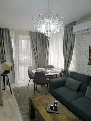 a living room with a blue couch and a table at Snowflake- Luxury stay with a Bottle of Wine,free Parking and SPA in Royal Park in Bansko