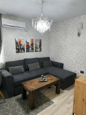 a living room with a blue couch and a table at Snowflake- Luxury stay with a Bottle of Wine,free Parking and SPA in Royal Park in Bansko